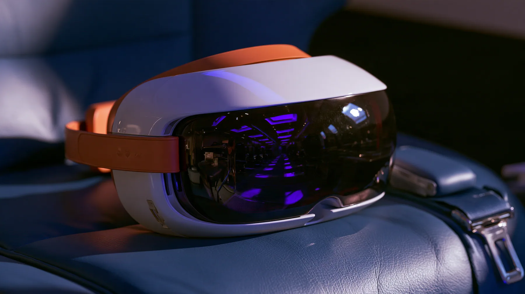Jet-set editorial product still life: a sleek glossy white virtual-reality headset visor with a clay-orange band resting on a navy leather airplane seat at night, the glossy black front glass reflecting violet cabin…
