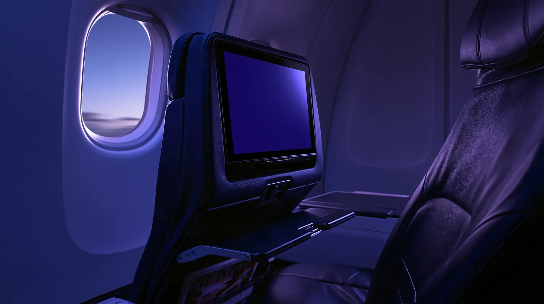 Jet-set editorial still life: the point of view from a window seat on a night flight, the seat-back screen in front glowing a blank deep navy, the tray table latched, a magazine in the seat pocket, the oval window at…