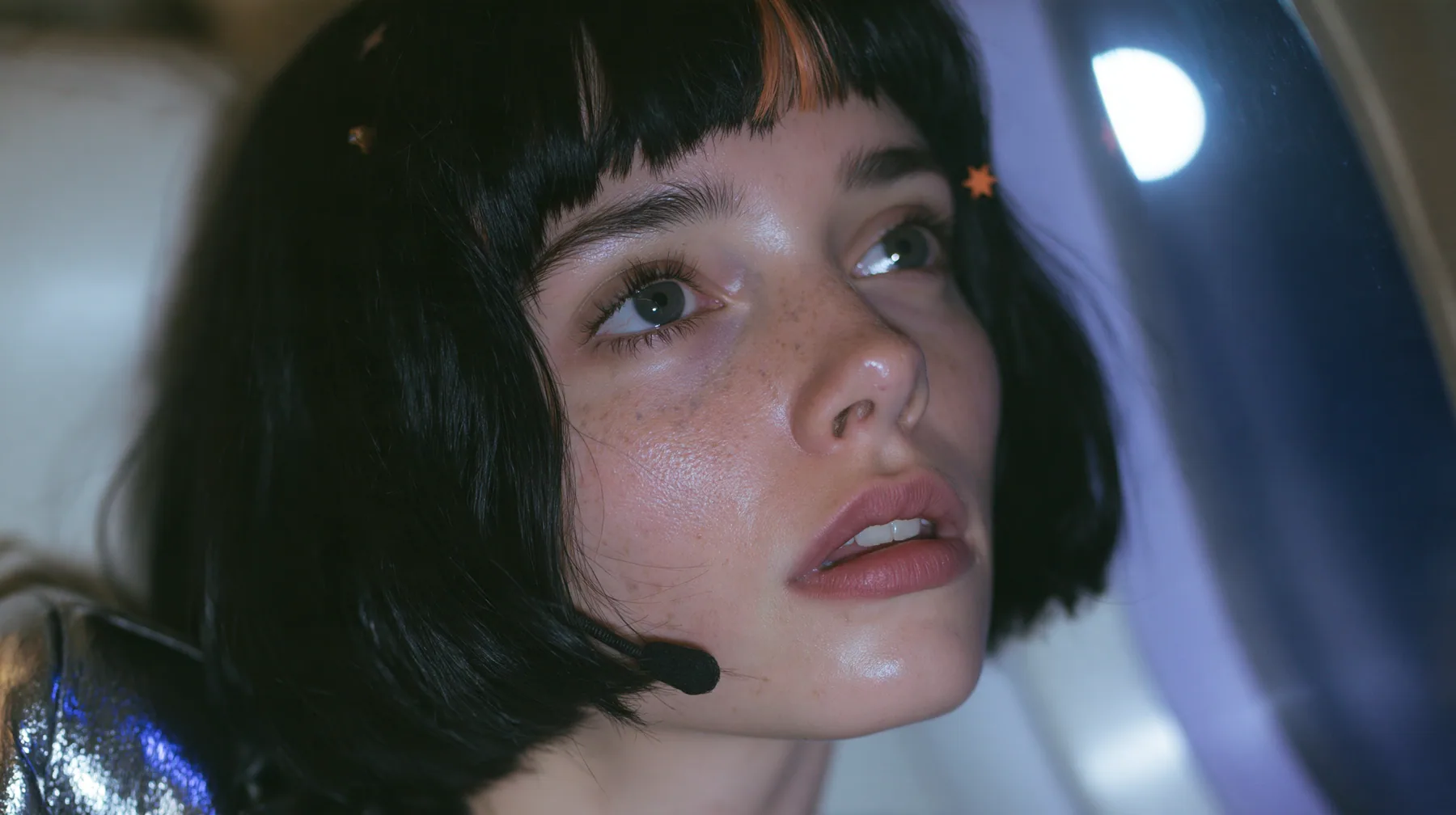 Jet-set high fashion editorial, a couture magazine story shot on a night flight: a close-up of a Caucasian American woman in her late twenties with a grown-up angular face, defined cheekbones and a strong jawline,…