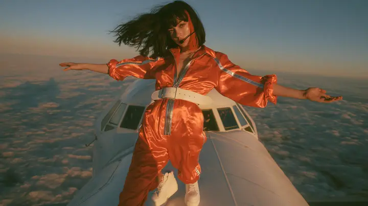 Jet-set high fashion editorial, a couture magazine story shot on a dawn flight: a full-length shot of a Caucasian American woman in her late twenties with pale skin and a glossy black blunt bob with heavy straight…