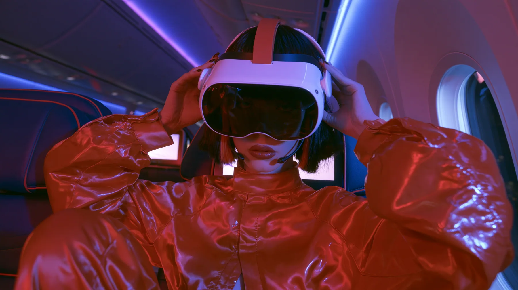 Jet-set fashion editorial, night flight: a medium close-up of a Caucasian American woman in her late twenties with pale skin and a glossy black blunt bob with heavy straight bangs and one clay-orange streak, a thin…