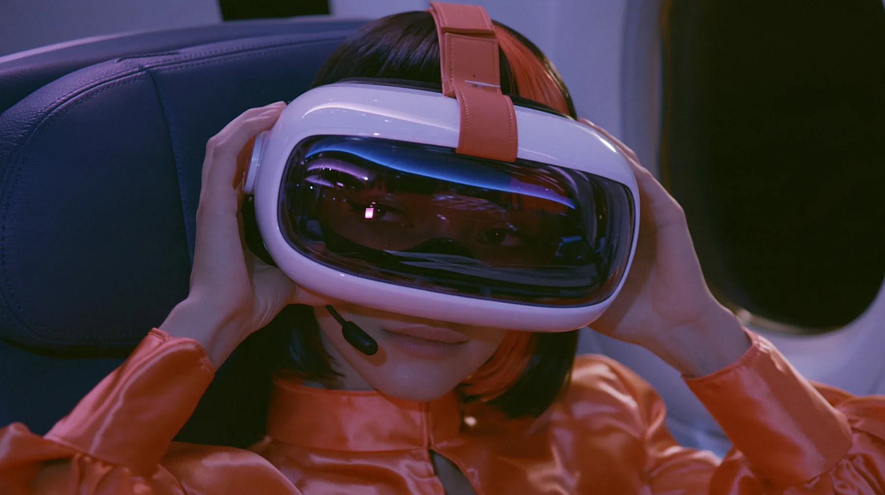 Jet-set fashion editorial, night flight: a medium close-up of a Caucasian American woman in her late twenties with pale skin and a glossy black blunt bob with heavy straight bangs and one clay-orange streak, a thin…