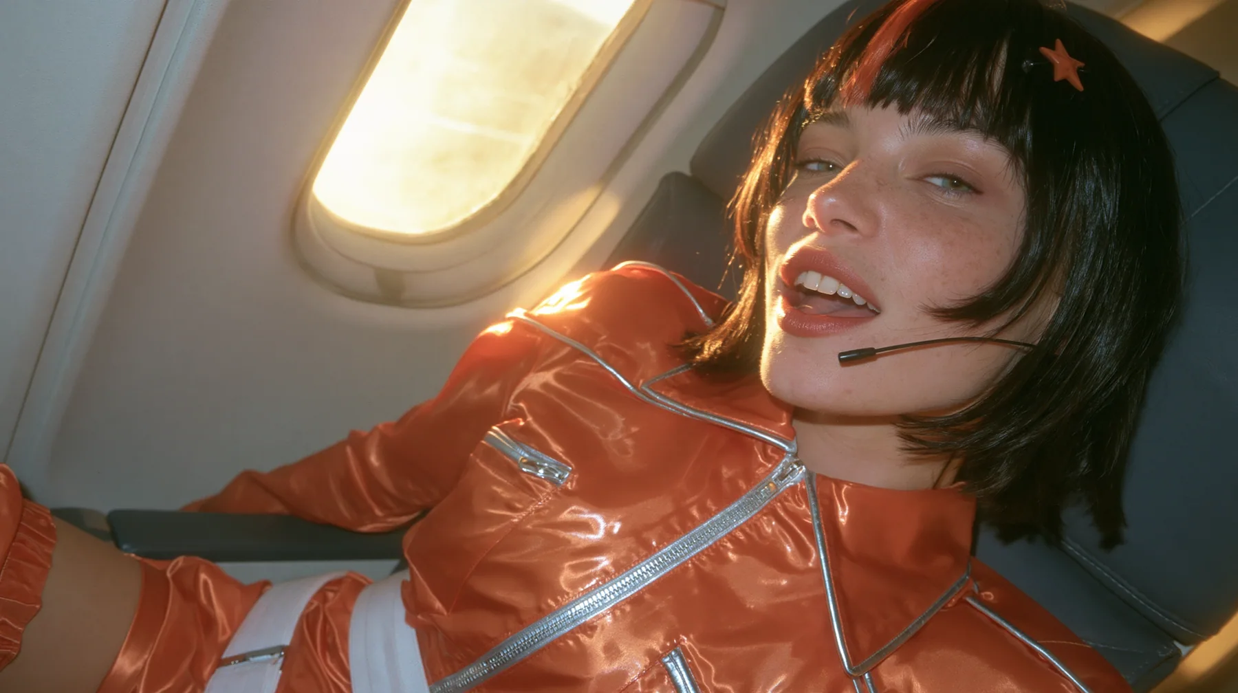 Jet-set fashion editorial, dawn flight: an eye-level medium close-up of a Caucasian American woman in her early thirties, a grown woman with elegant mature features, an angular face and defined cheekbones, pale…