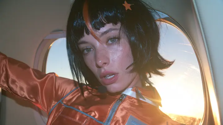 Jet-set fashion editorial, sunrise flight: an eye-level close-up of a Caucasian American woman in her early thirties, a grown woman with elegant mature features, an angular face and defined cheekbones, pale freckled…