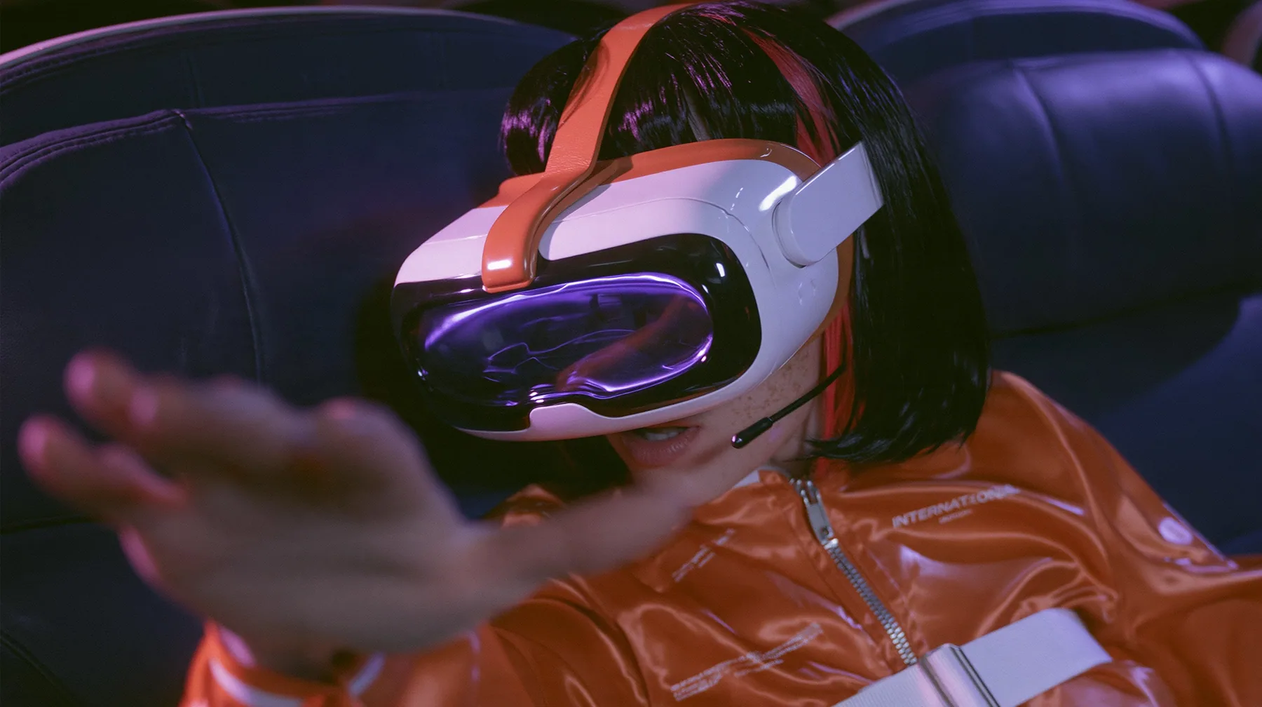 Jet-set fashion editorial, night flight: a Caucasian American woman in her early thirties, an angular adult face, pale freckled skin, a glossy black blunt bob with heavy bangs and one clay-orange streak, a thin black…