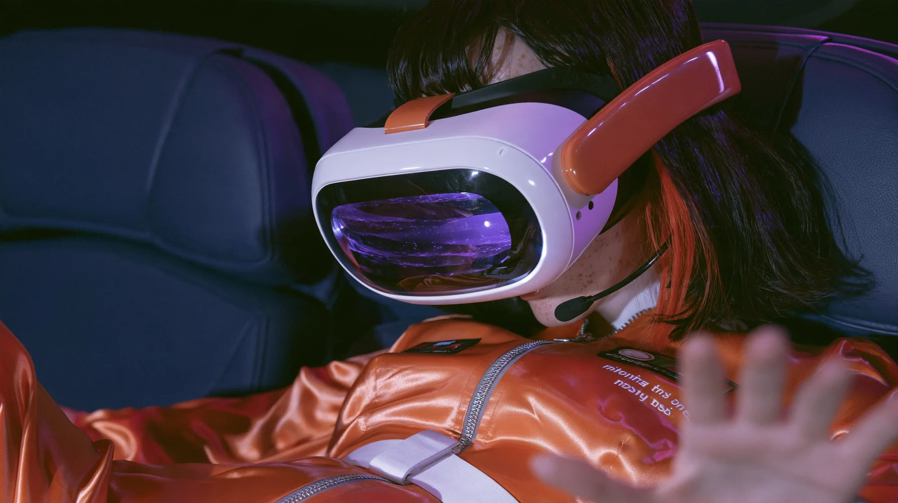 Jet-set fashion editorial, night flight: a Caucasian American woman in her early thirties, an angular adult face, pale freckled skin, a glossy black blunt bob with heavy bangs and one clay-orange streak, a thin black…