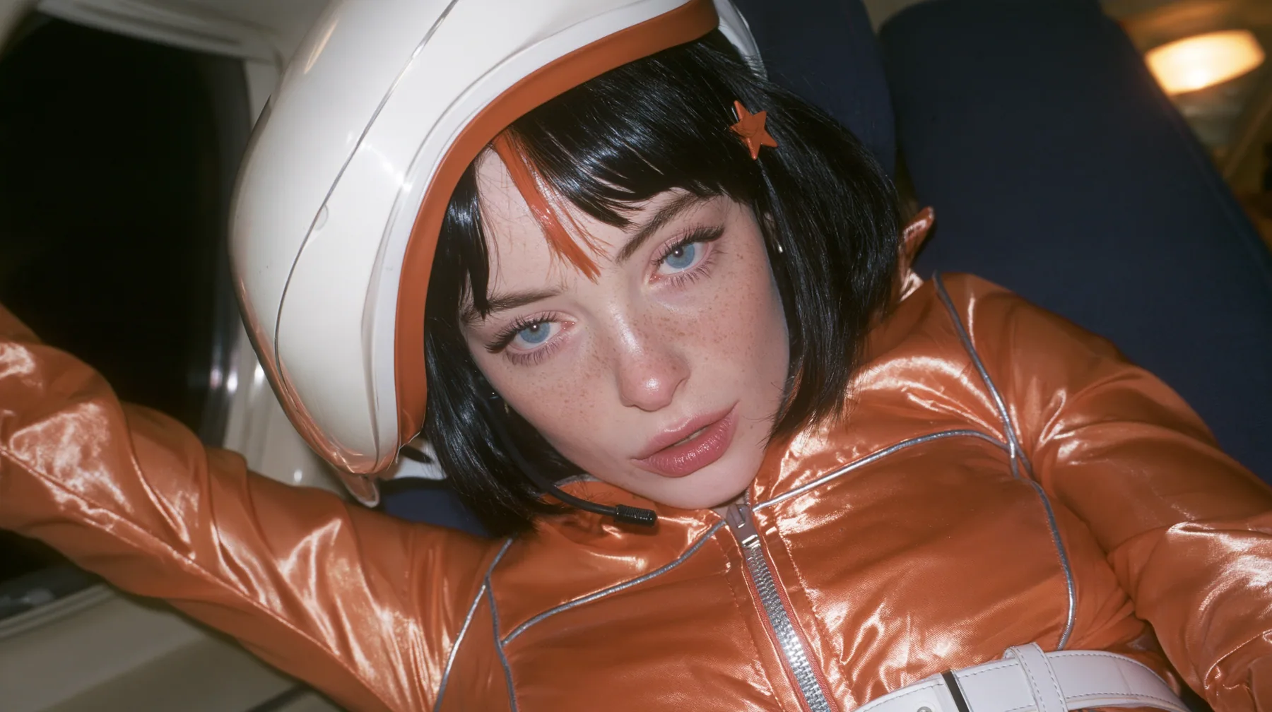 Jet-set fashion editorial, night flight: an eye-level close-up of a Caucasian American woman in her early thirties, a grown woman with elegant mature features, an angular face and defined cheekbones, pale freckled…