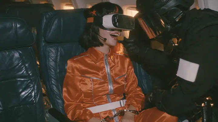Cinematic film still, night airliner cabin with navy leather seats, all of them empty: a Caucasian woman in her early thirties with an angular adult face, pale freckled skin, a glossy black blunt bob with heavy bangs…