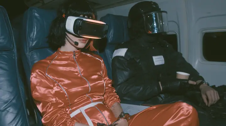 Cinematic film still at 3 AM, dim blue night airliner cabin with navy leather seats, all of them empty: a Caucasian woman in her early thirties with an angular adult face, pale freckled skin, a glossy black blunt bob…