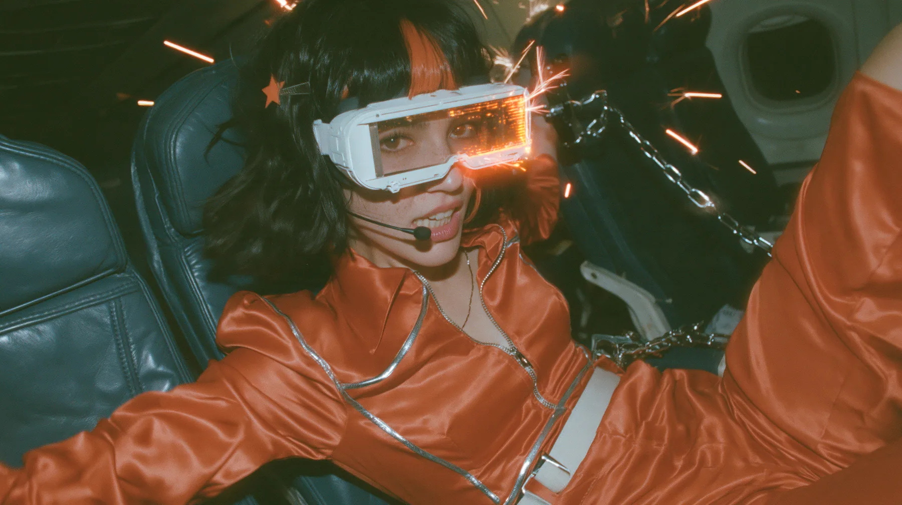 Intense cinematic film still, night airliner cabin with navy leather seats, all of them empty: a Caucasian woman in her early thirties with an angular adult face, pale freckled skin, a glossy black blunt bob with…