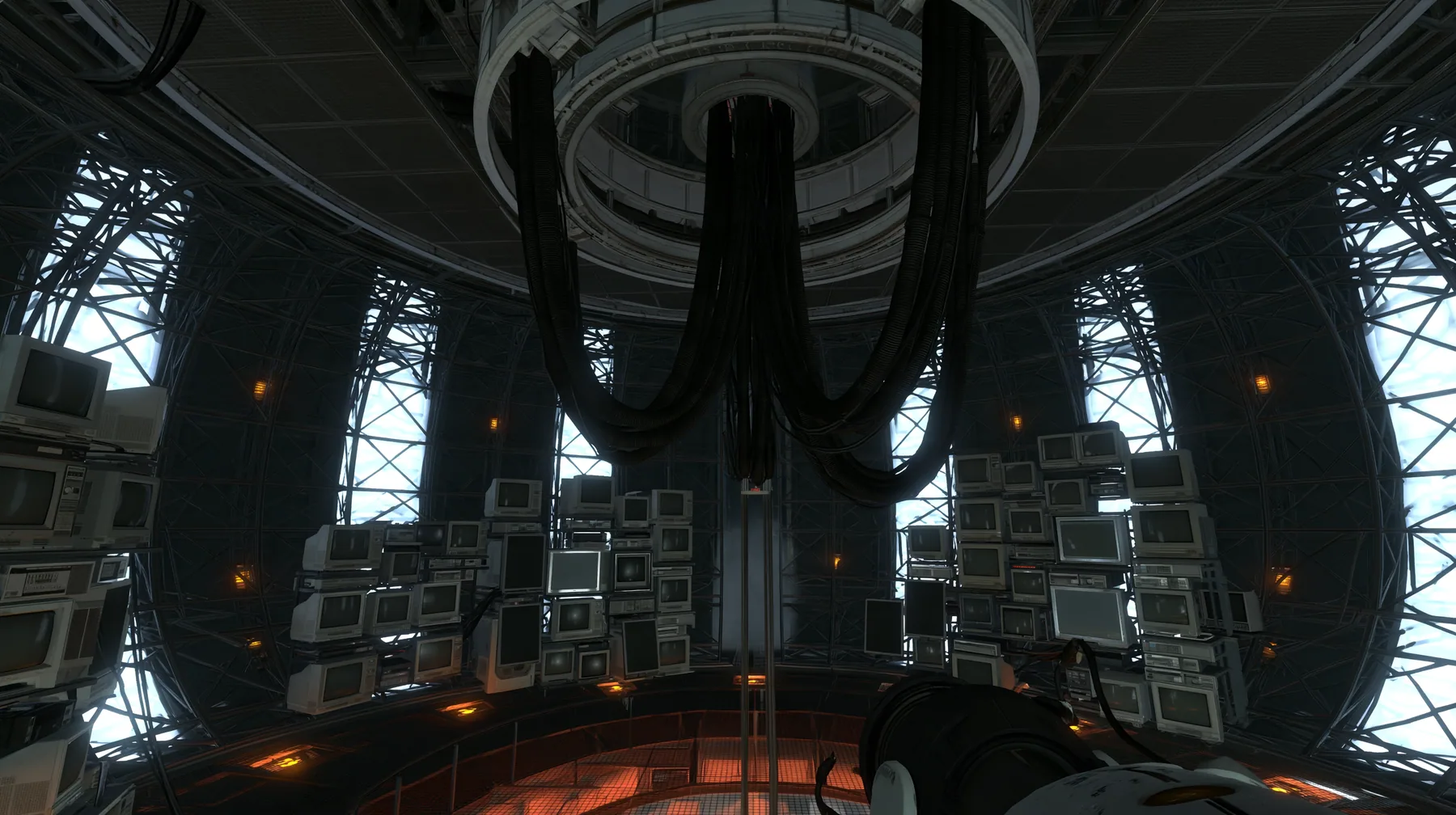 Portal 2 (2011) Source engine screenshot, Valve, the empty Aperture Science central AI chamber: the ceiling ring mount with thick black cables hanging down, dozens of old CRT monitors and flat panel screens stacked…