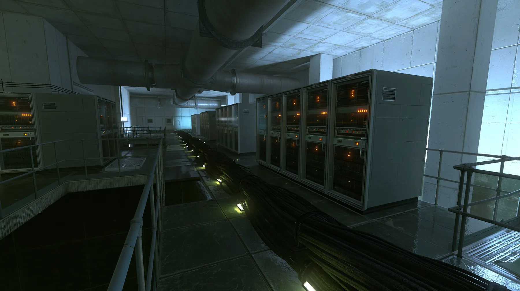 Portal 2 (2011) Source engine screenshot, Valve, behind the scenes at Aperture Science: a long concrete corridor lined with tall 1970s mainframe server cabinets with blinking lights, thick black cable bundles along…