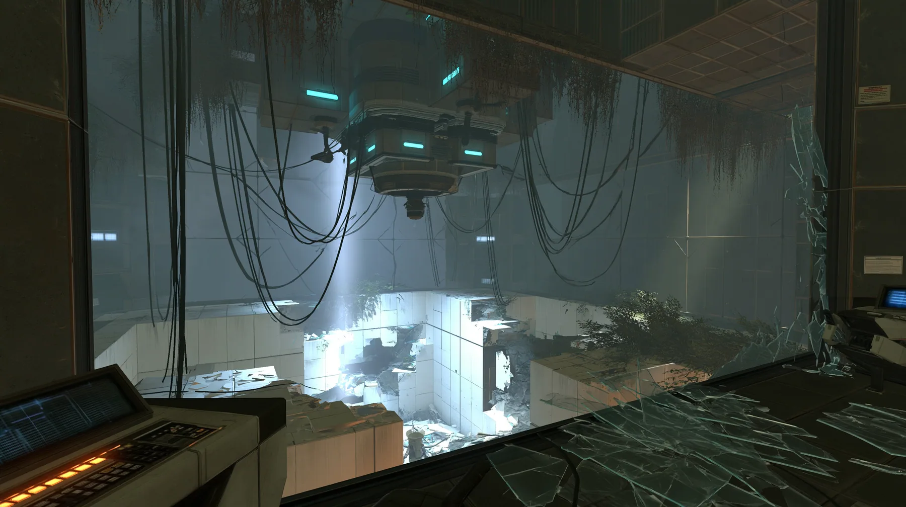 inside a dark control booth high above a test chamber, its big observation window smashed outward, shards of glass on the console and floor, a ruined white panelled chamber below, hanging cables, cyan indicator…