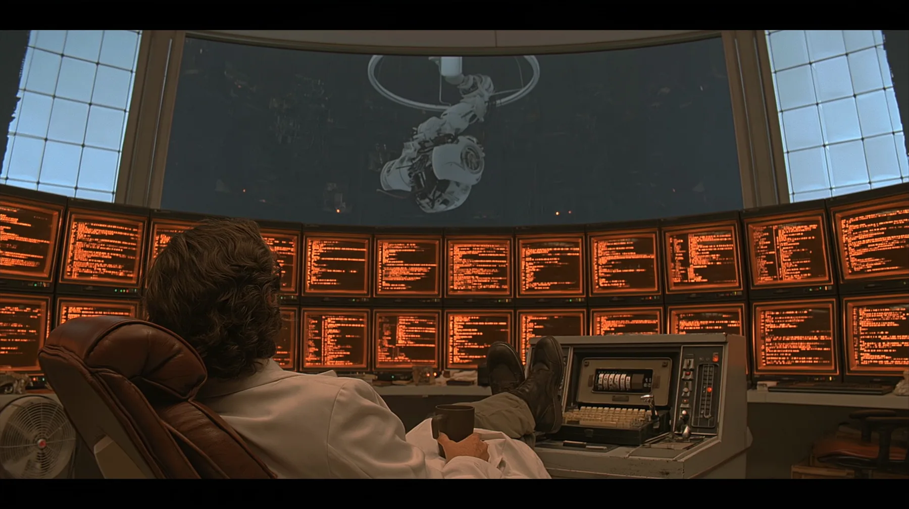 cinematic film still from behind: a curly-haired scientist in a white lab coat leans back in a leather chair, feet up on a retro control console, coffee mug in hand, facing a curved wall of amber CRT monitors full of…