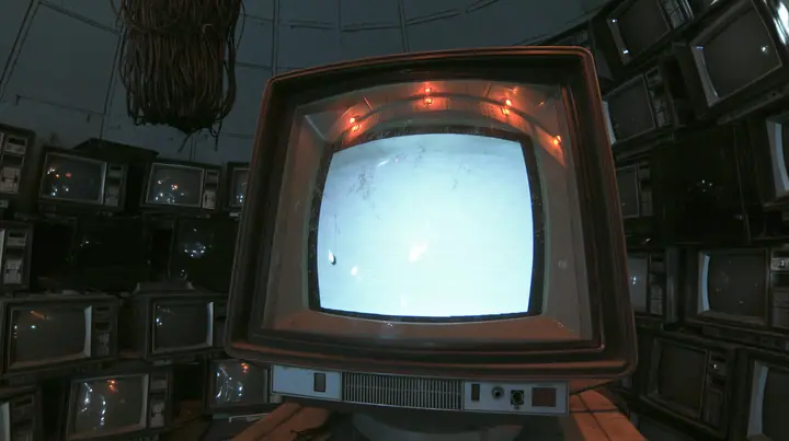 extreme macro shot of the curved glass of a single 1970s CRT monitor waking up in a pitch-dark machine chamber, a faint green-white phosphor bloom swelling at the centre of the screen, one blinking block cursor, fine…