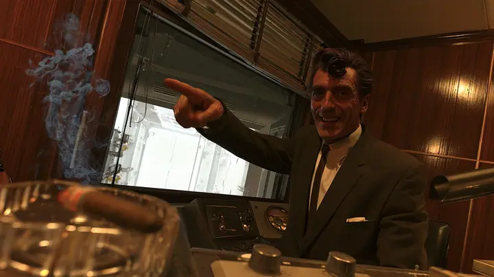 low-angle cinematic shot in a 1950s observation booth: a lean grinning executive with a long face, a long straight nose, a big toothy showman's grin, a dark wavy pompadour, a charcoal suit and thin dark tie points…