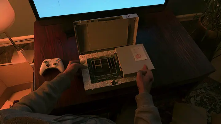 Top-down cinematic film still: on a dark wooden coffee table hands in a grey hoodie pull the cover off a new white game console in its foam tray, its circuit board bare with empty memory slots and a little paper slip…