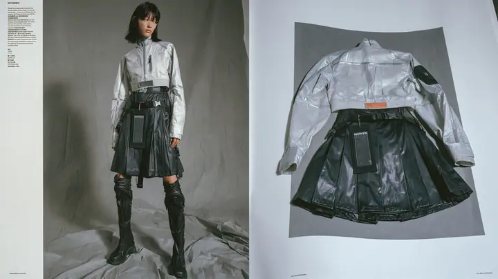 two-page techwear lookbook spread: on the left a full-length photograph of a young woman in a technical cropped shell top in pale grey ripstop with taped seams and a woven label at the hem, high-waisted pleated…