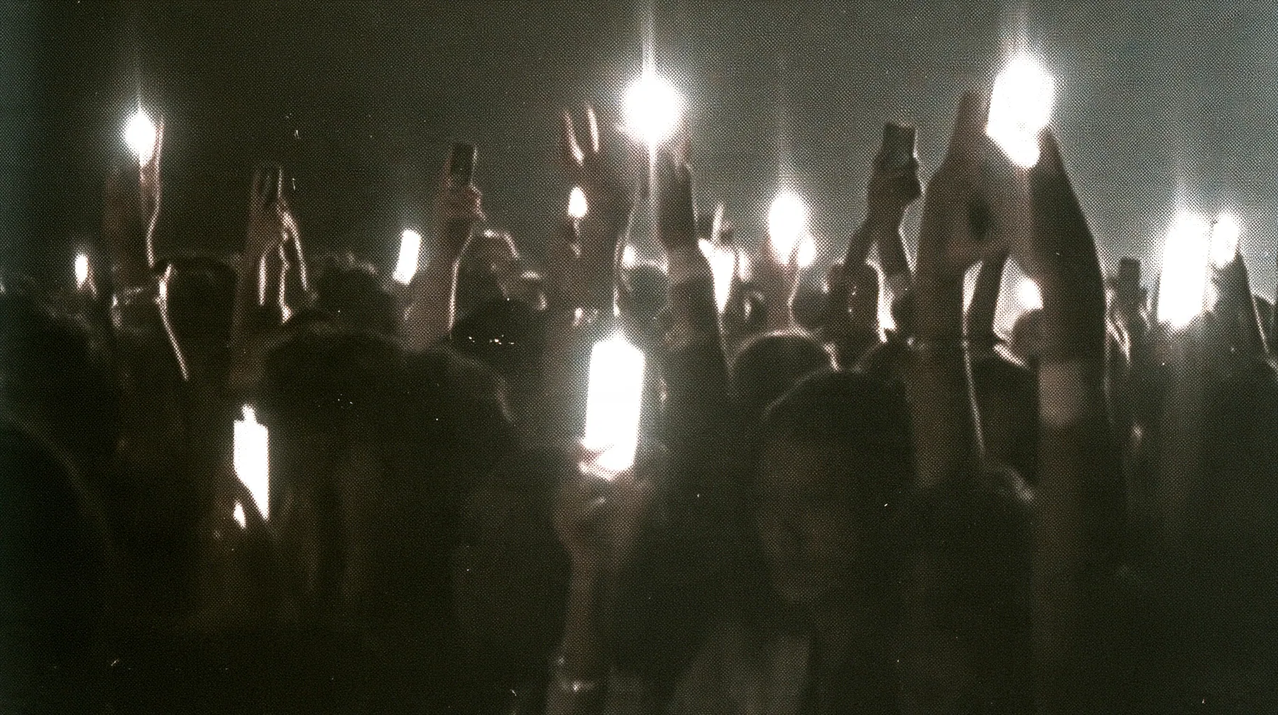 a 1-bit ordered-dither photocopy of a crowd of silhouetted fashion-show guests holding up glowing phones, coarse dither in black toner on off-white paper, copier edge burn, one scanline drop-out band, no grey tones,…