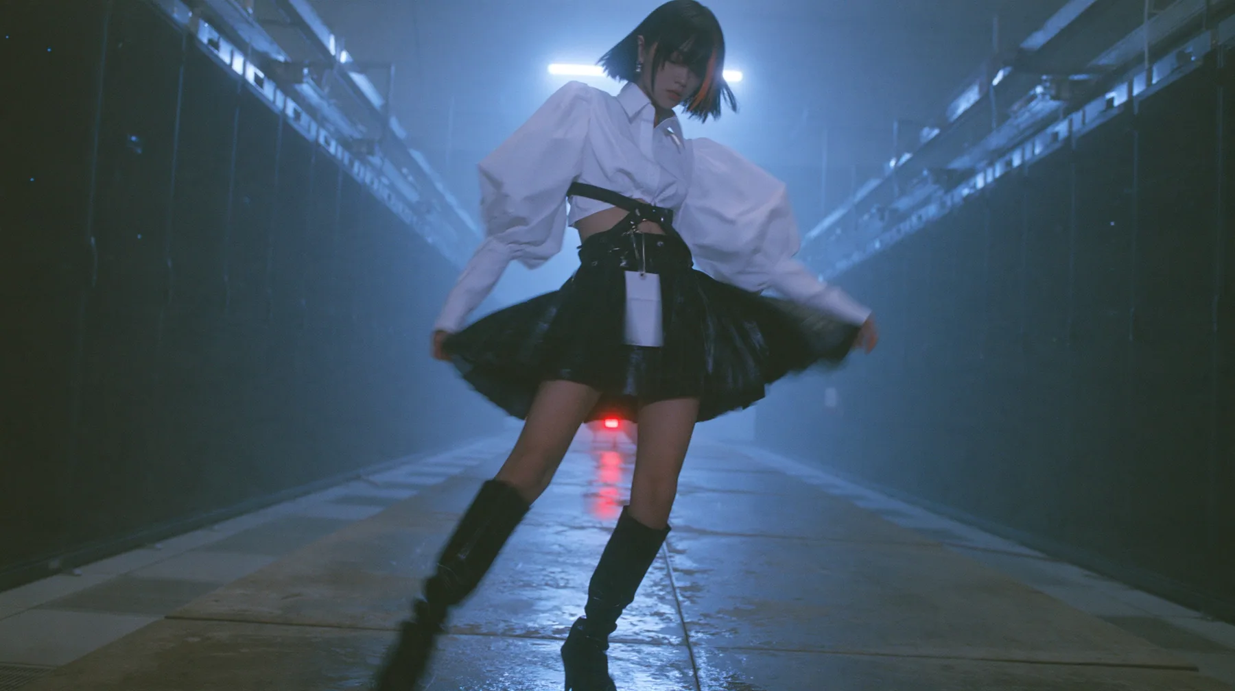 full-length shot of a young woman with a glossy black blunt bob with heavy bangs and one clay-orange streak, a white cropped puff-sleeve shirt, a black pleated skirt with a harness belt and a hanging white garment…