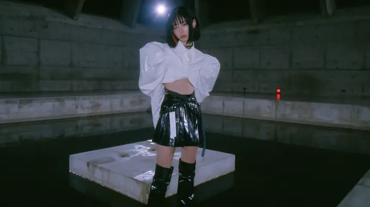 a young woman with a glossy black blunt bob with heavy bangs and one clay-orange streak, a white cropped puff-sleeve shirt, a black pleated skirt with a harness belt and a hanging white garment tag, black knee-high…