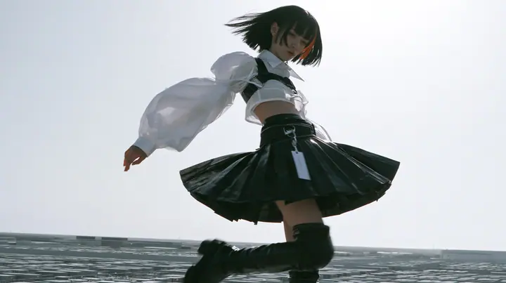 a young woman with a glossy black blunt bob with heavy bangs and one clay-orange streak, a white cropped puff-sleeve shirt, a black pleated skirt with a harness belt and a hanging white garment tag, black knee-high…
