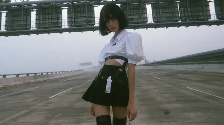a young Caucasian American woman with pale skin and light freckles, a glossy black blunt jaw-length bob with heavy bangs and one clay-orange streak through the bangs, a small flat clay-orange eight-pointed star hair…