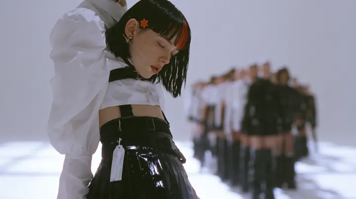 a young Caucasian American woman with pale skin and light freckles, a glossy black blunt jaw-length bob with heavy bangs and one clay-orange streak through the bangs, a small flat clay-orange eight-pointed star hair…