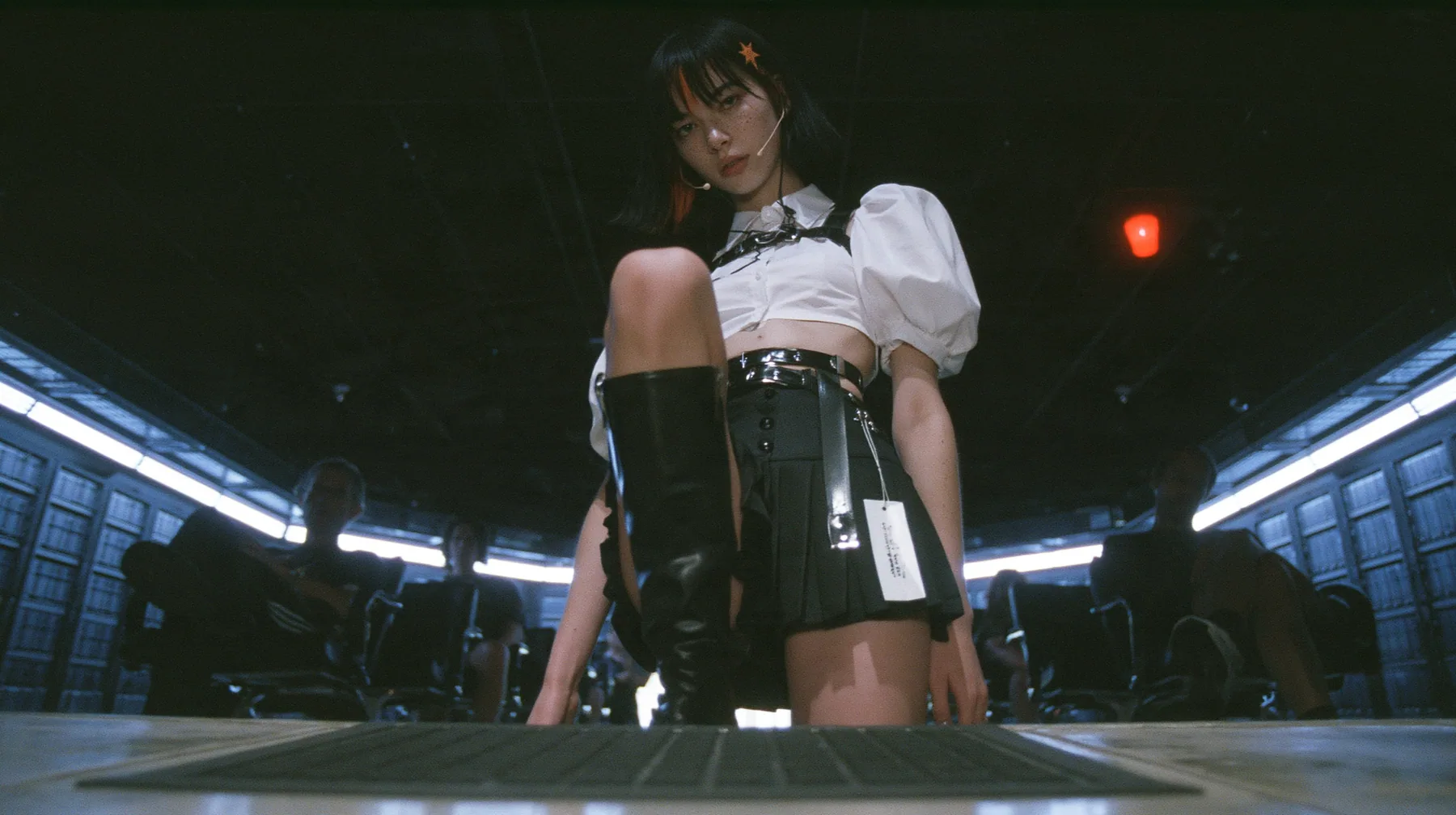 low-angle full-length view of a young Caucasian American woman with pale skin and light freckles, a glossy black blunt jaw-length bob with heavy bangs and one clay-orange streak through the bangs, a small flat…