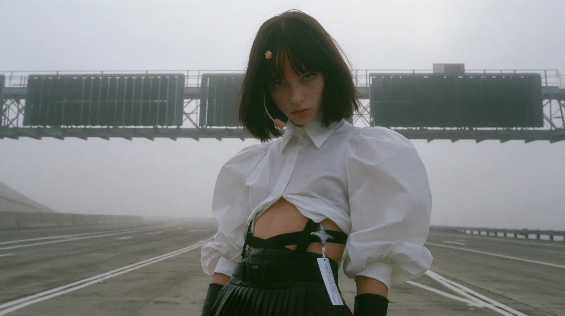 three enormous split-flap signs on steel gantries spanning an empty freeway in white fog, blank black flaps, a young Caucasian American woman with pale skin and light freckles, a glossy black blunt jaw-length bob…