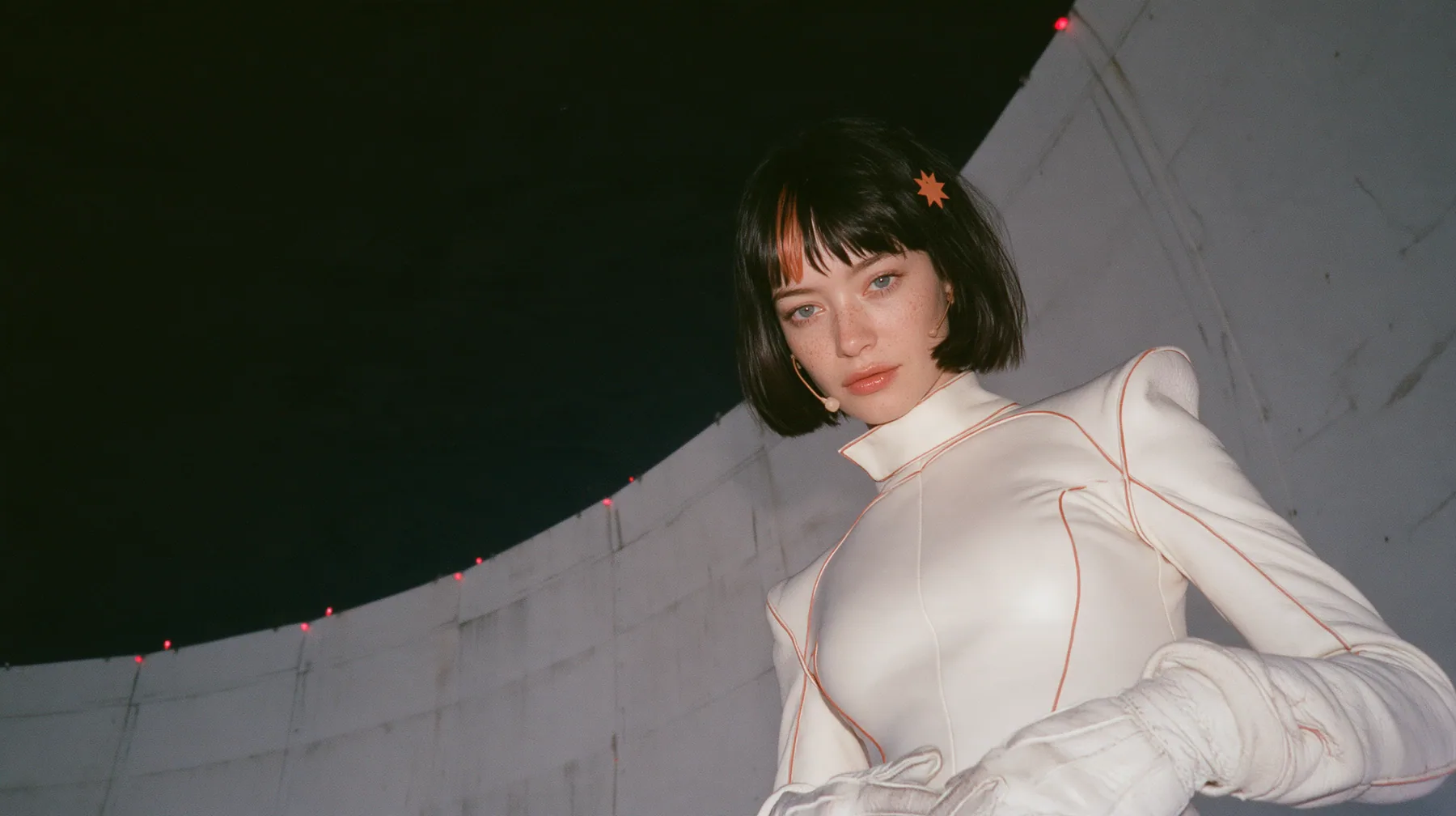 medium shot, a 28-year-old Caucasian American woman with a grown-up angular face, defined cheekbones and a strong jawline, pale skin and light freckles, a glossy black blunt jaw-length bob with heavy straight bangs…