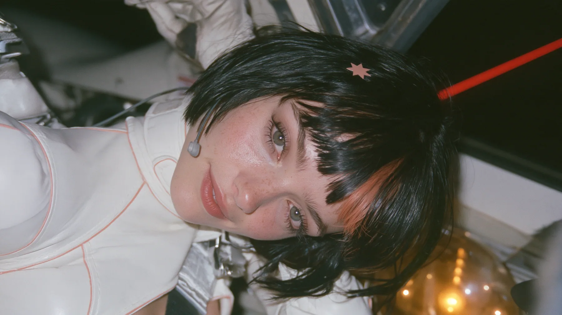 close-up, a 28-year-old Caucasian American woman with a grown-up angular face, defined cheekbones and a strong jawline, pale skin and light freckles, a glossy black blunt jaw-length bob with heavy straight bangs and…