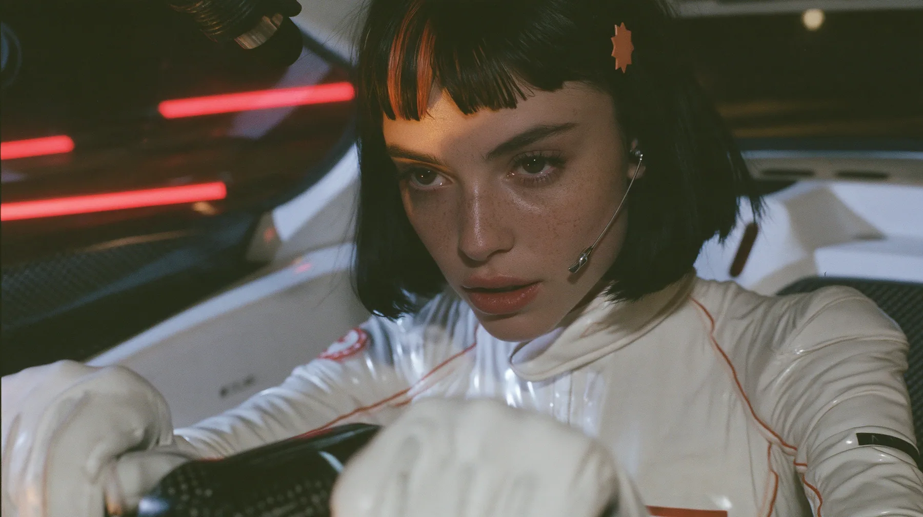 close-up of her two white-gloved hands on the yoke, her chin and headset microphone at the top edge of the frame, a 28-year-old Caucasian American woman with a grown-up angular face, defined cheekbones and a strong…