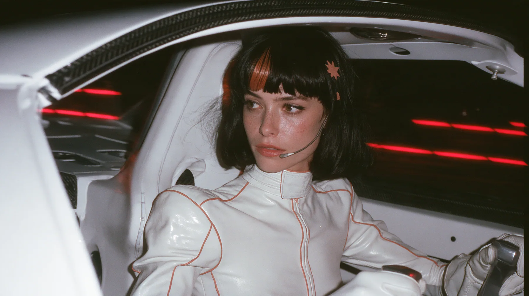 medium close-up from the passenger side across an empty stripped passenger bay, a 28-year-old Caucasian American woman with a grown-up angular face, defined cheekbones and a strong jawline, pale skin and light…