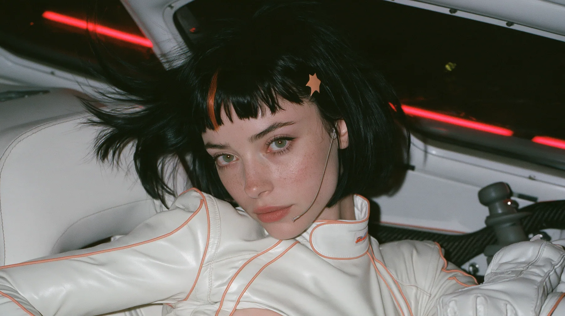 medium close-up, eye level, a 28-year-old Caucasian American woman with a grown-up angular face, defined cheekbones and a strong jawline, pale skin and light freckles, a glossy black blunt jaw-length bob with heavy…