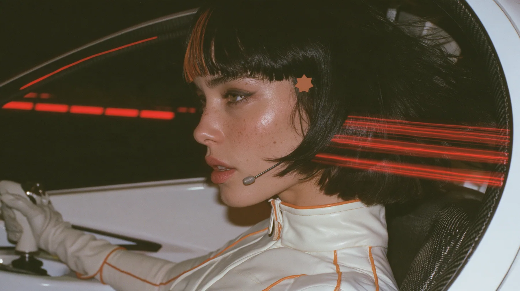 profile close-up, a 28-year-old Caucasian American woman with a grown-up angular face, defined cheekbones and a strong jawline, pale skin and light freckles, a glossy black blunt jaw-length bob with heavy straight…