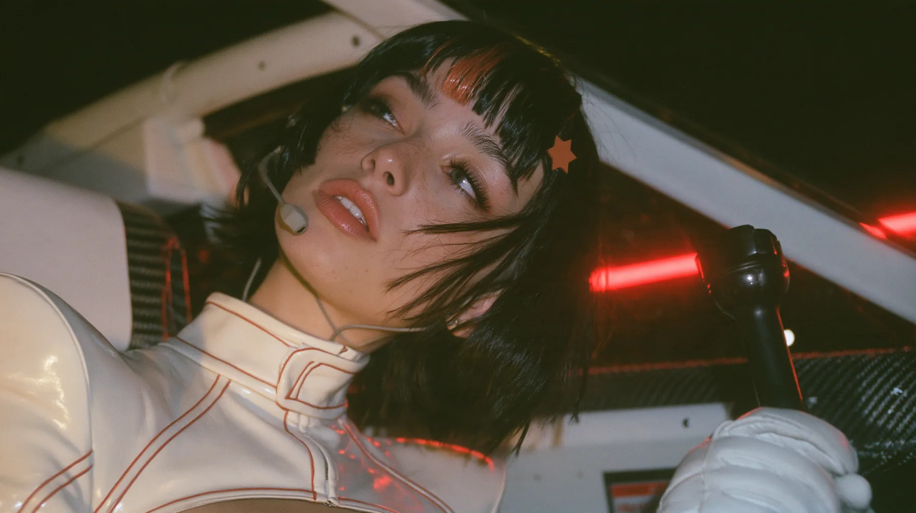 profile close-up, a 28-year-old Caucasian American woman with a grown-up angular face, defined cheekbones and a strong jawline, pale skin and light freckles, a glossy black blunt jaw-length bob with heavy straight…