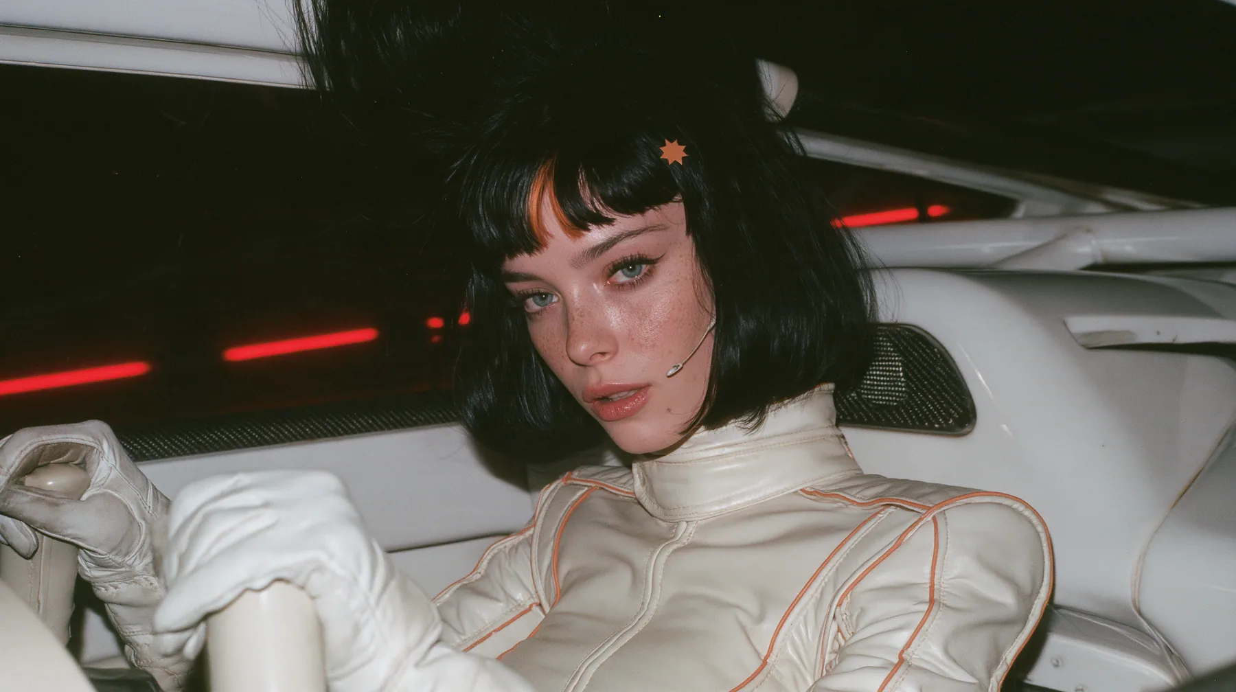medium shot from the passenger side, a 28-year-old Caucasian American woman with a grown-up angular face, defined cheekbones and a strong jawline, pale skin and light freckles, a glossy black blunt jaw-length bob…