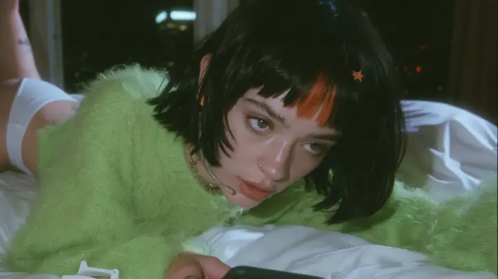 medium shot at mattress height, a 28-year-old Caucasian American woman with a grown-up angular face, defined cheekbones and a strong jawline, pale skin and light freckles, a glossy black blunt jaw-length bob with…