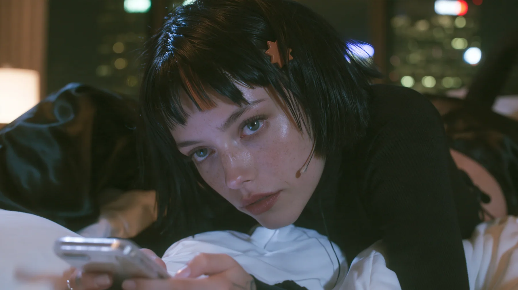 medium shot at mattress height, a 28-year-old Caucasian American woman with a grown-up angular face, defined cheekbones and a strong jawline, pale skin and light freckles, a glossy black blunt jaw-length bob with…