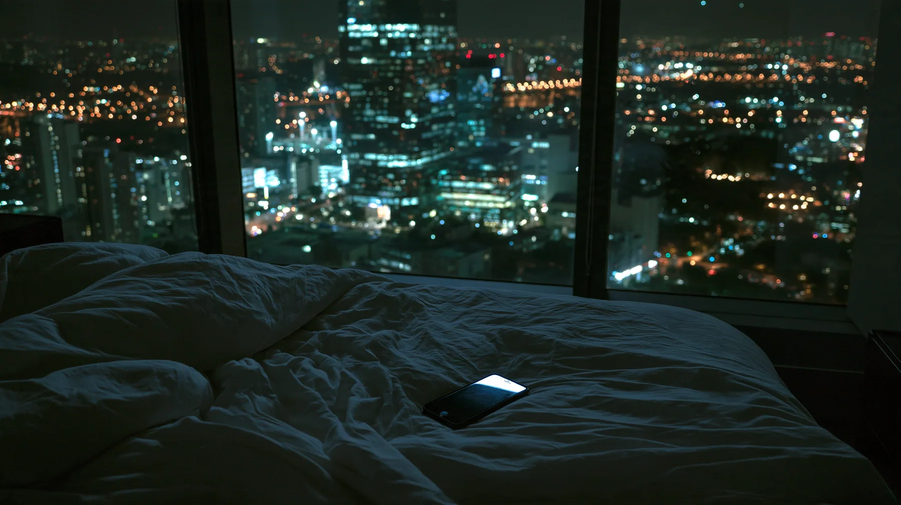 a dark minimal high-rise bedroom at night, a smartphone lying face down on rumpled white sheets, a floor-to-ceiling window of glittering city lights behind, no people, deep shadows, cinematic, no text, no letters, no…