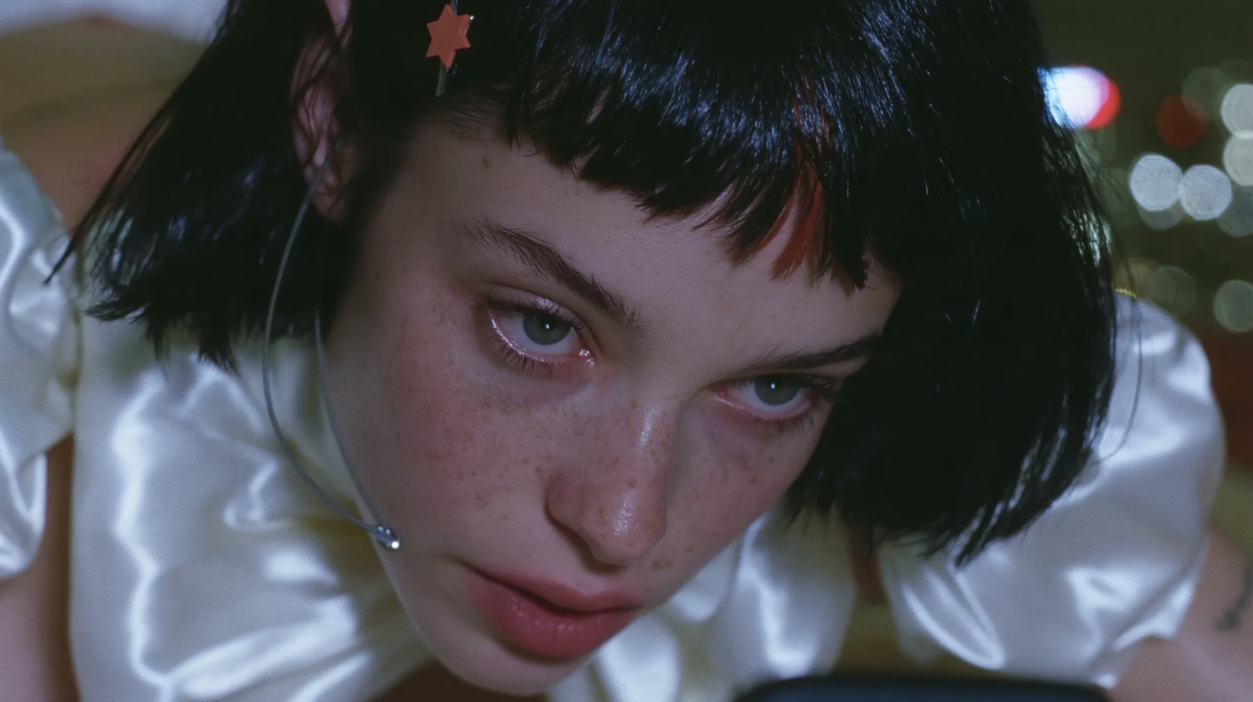 close-up, a 28-year-old Caucasian American woman with a grown-up angular face, defined cheekbones and a strong jawline, pale skin and light freckles, a glossy black blunt jaw-length bob with heavy straight bangs and…