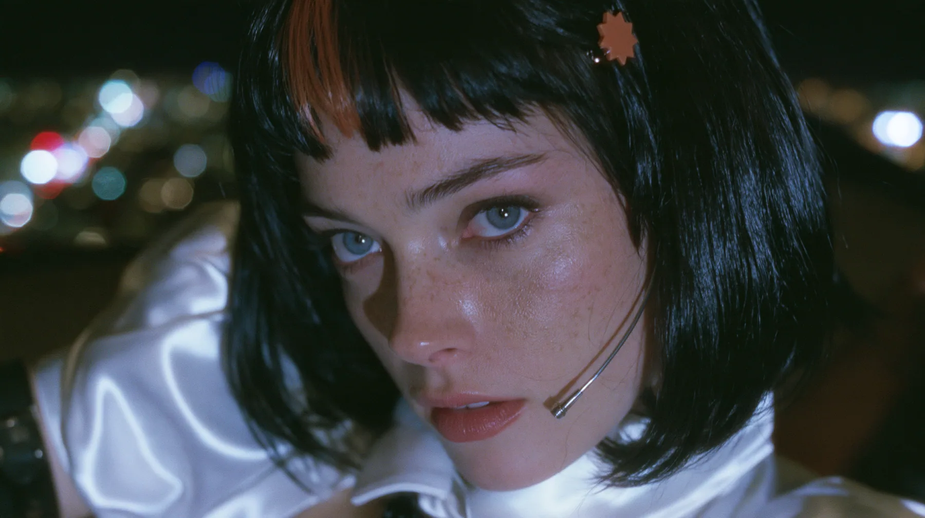 close-up, a 28-year-old Caucasian American woman with a grown-up angular face, defined cheekbones and a strong jawline, pale skin and light freckles, a glossy black blunt jaw-length bob with heavy straight bangs and…