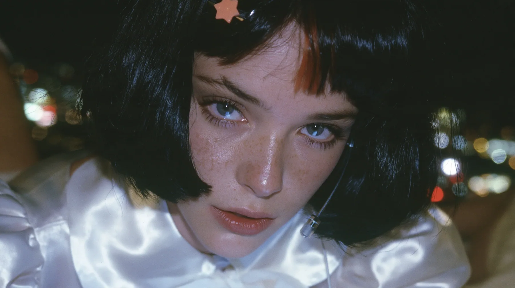 close-up, a 28-year-old Caucasian American woman with a grown-up angular face, defined cheekbones and a strong jawline, pale skin and light freckles, a glossy black blunt jaw-length bob with heavy straight bangs and…