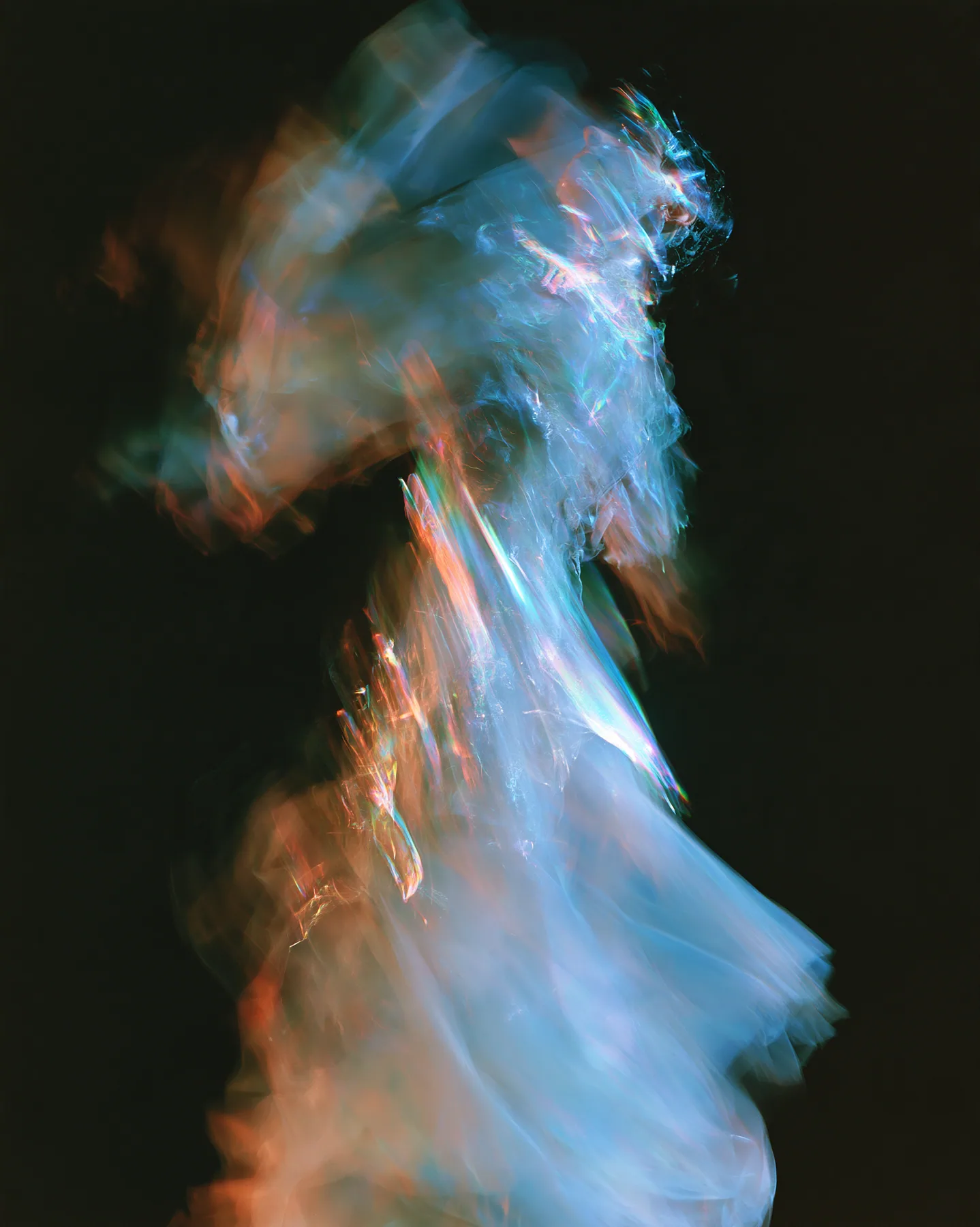 an abstract motion-blurred photograph of a dancing figure dissolving into streaks of iridescent light, black background, no face, no text, no letters, no logos