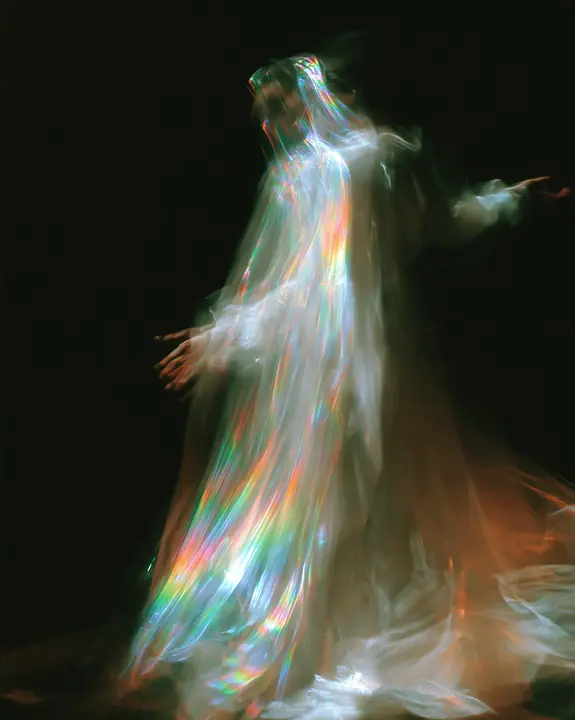 an abstract motion-blurred photograph of a dancing figure dissolving into streaks of iridescent light, black background, no face, no text, no letters, no logos