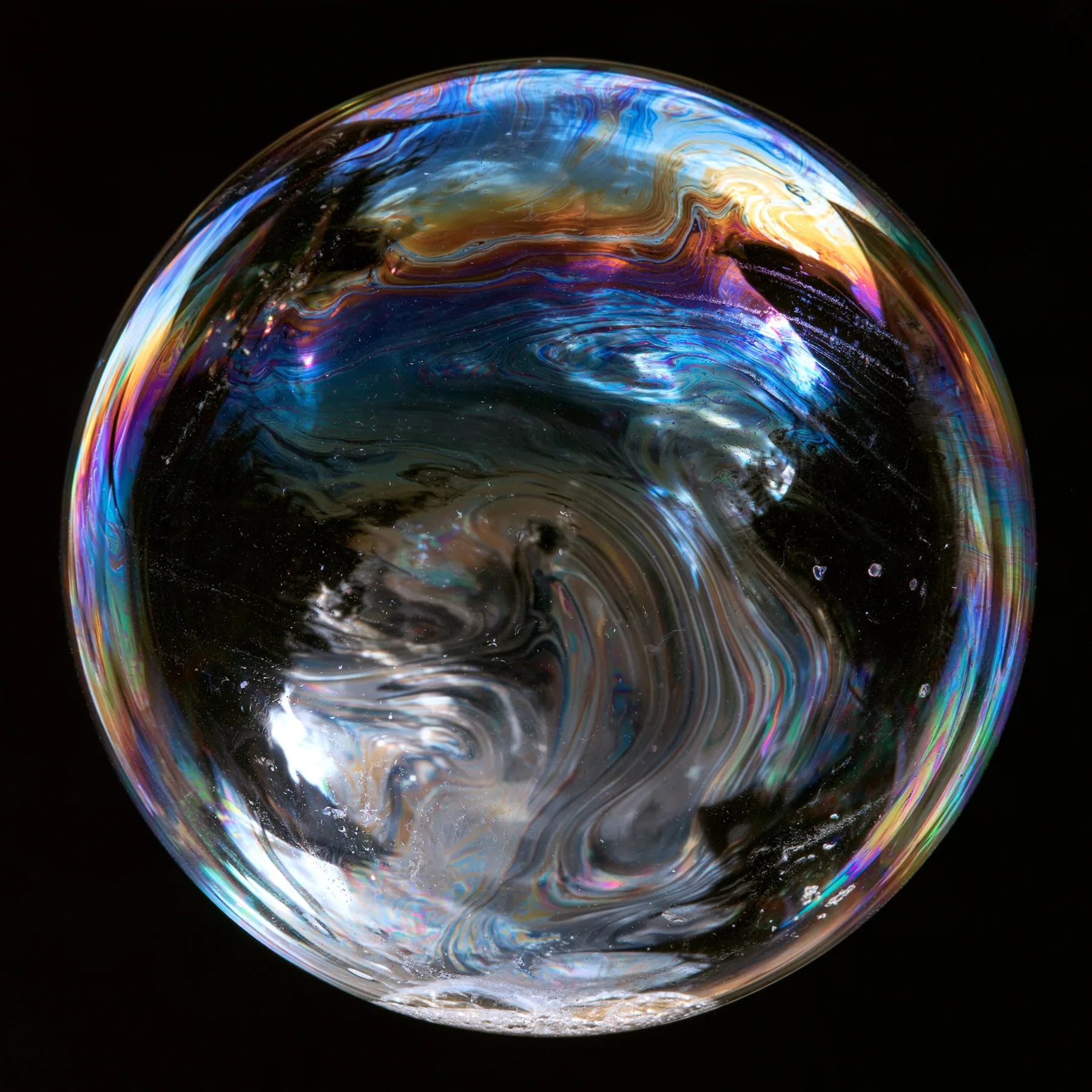 macro of a soap film with swirling iridescent interference colours on black, scientific photograph, no text, no letters, no logos