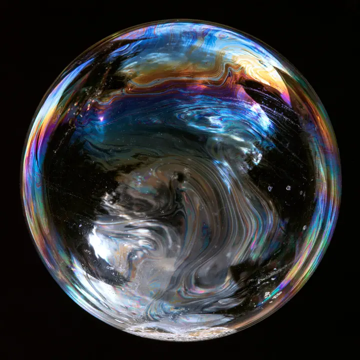 macro of a soap film with swirling iridescent interference colours on black, scientific photograph, no text, no letters, no logos