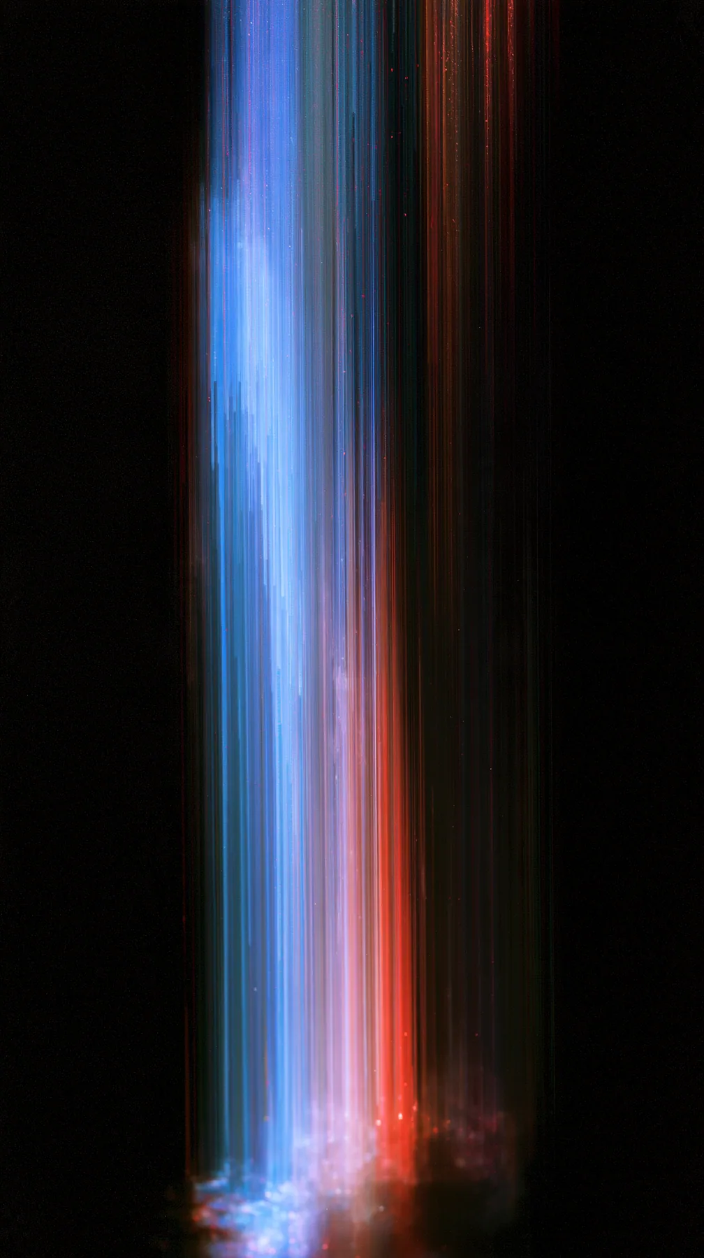 a photograph smeared vertically into long streaks of colour like dragged pixels, deep blues and reds on black, no text, no letters, no logos