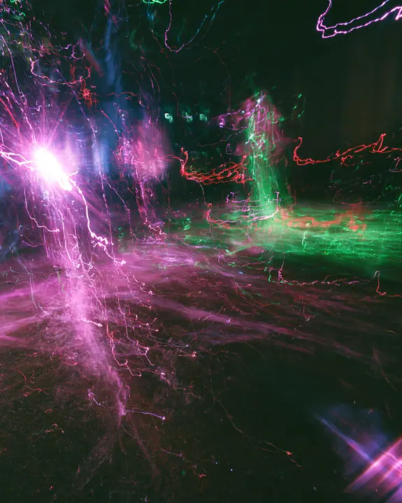 a long-exposure photograph of magenta and acid-green light trails over a dark dance floor, smeared, euphoric, no text, no letters, no logos